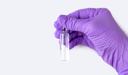 woman doctor in purple gloves isolated in gray holding sodium chloride solution in glass ampule...