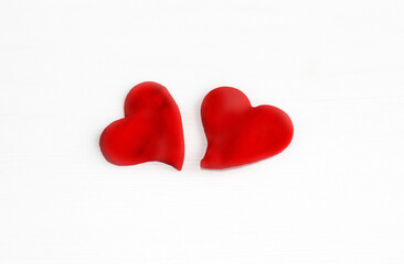 kid playing with plasticine clay making colorful hearts or holding one red heart at mouth.happy or sad upset emoticon made by child preschooler pointing with index finger.valentine day love february