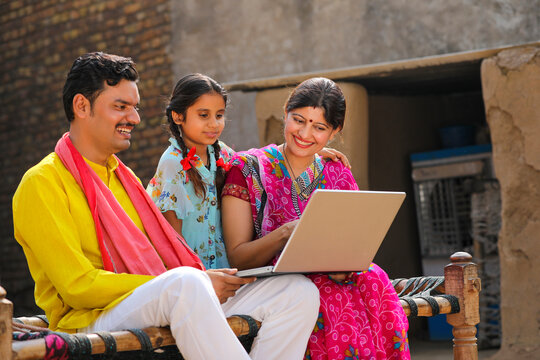 Indian Rural Family Using Laptop At Home.