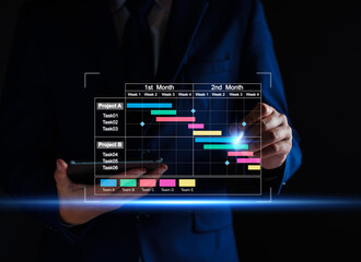 Project manager working on tablet and updating tasks and milestones progress planning with Gantt chart scheduling interface for company on virtual screen. Business Project Management System.