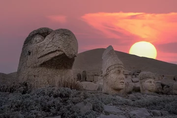  View of mount Nemrut and monumental sculptures of commagene kings and gods with colorful clouds and sun at sky © Aytug Bayer