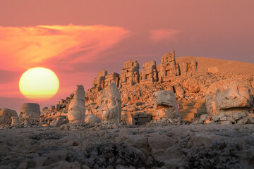 View of mount Nemrut and monumental sculptures of commagene kings and gods with colorful clouds and sun at sky