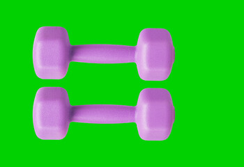 Purple female dumbbells for sports in the gym and at home. Isolated on a green background.