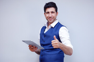 Businessman or young man in suit smiling holding tablet on white background.