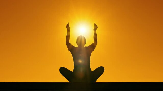 outdoor meditation mindfullness silhouette of woman relaxing at sunset.mov