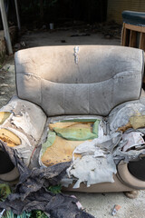 a badly damaged sofa in the outdoor at vertical composition