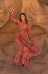 Portrait of a young girl wearing a red dress holding a rock in Al Ola, Saudi