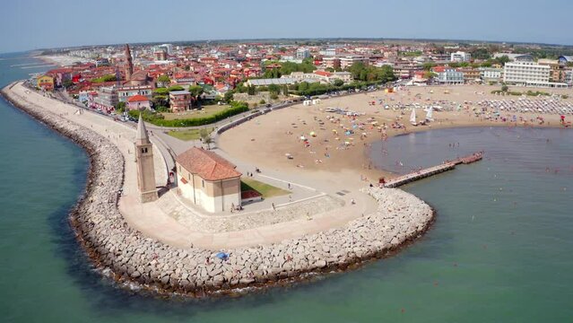 4k drone flight down footage (Ultra High Definition) of Madonna dell'Angelo church - small seaside chapel and pilgrimage destination. Bright cityscape of Caorle town, Italy.
