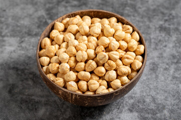 Roasted hazelnuts in bowl on dark background. Nuts in a coconut bowl. close up