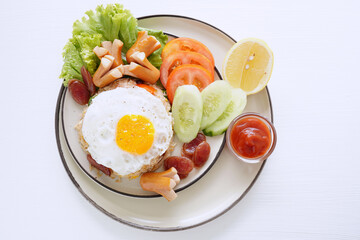 Fried rice and hot dogs, cooked fried egg, Chinese sausage and ketchup on a white background.