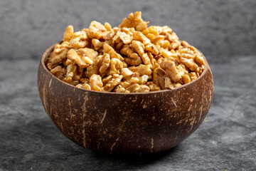 Walnuts in a bowl on a dark background. Walnuts in a coconut bowl. close up