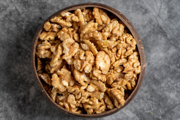 Walnuts in a bowl on a dark background. Walnuts in a coconut bowl. Top view