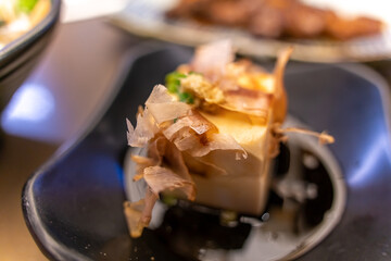 Close up of japanese tofu, Japanese soft cold tofu with sauce in a dish on dining table