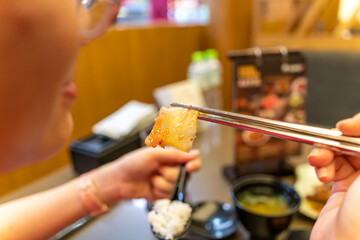 Asian woman's hand holding chopsticks to pick up food
