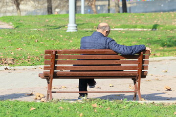 rear view of a man sitting on a bench