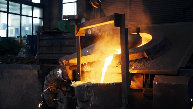 Pouring bright hot liquid steel or metal from ladle in blast furnace foundry metallurgical factory. Steel mill iron smelting process with bright sparks and smoke. 4K