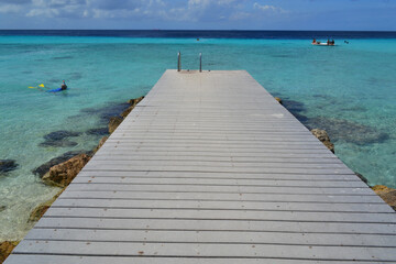 Obraz premium a beautiful wooden pier on a paradise beach on the island of Curacao in the caribbean sea