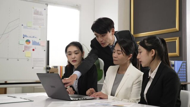 asian business partners sitting in creative meeting room expressing thoughts about online project. their hand gesturing at laptop computer while talking