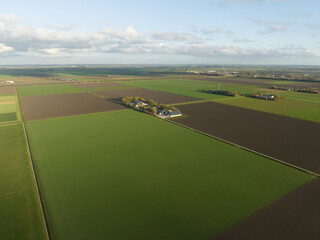 Agriculture modern farm house residential in wide open empty green field. Panorama aerial overhead...
