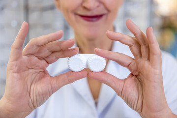 Close up of females hands holding contact lenses