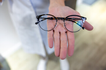 Close up of females hands with eyeglasses and lenses