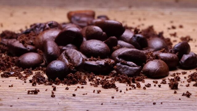 Coffee beans and ground coffee on wooden background. Macro shot. 