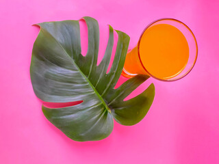 green tropical leaf and glass of juice