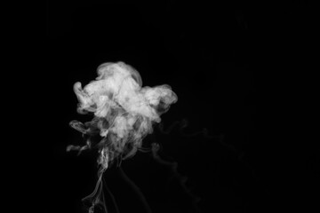 White smoke vapor in the form of a flying cloud is isolated on a black background to overlay your photos.