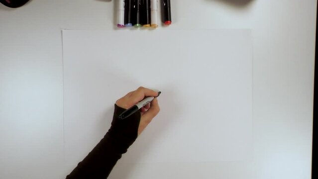 main d'une dessinatrice en train de dessiner un personnage f&eacute;minin