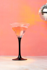 Martini glass with cocktail on a pink background