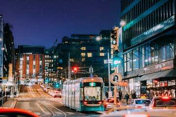 Obraz premium Helsinki, Finland. Colourful Night Starry Sky In Blue Colors. Tram Departs From A Stop On Kaivokatu Street In Helsinki. Night View Of Kaivokatu Street In Evening Or Night Illumination. Sky Gradient.