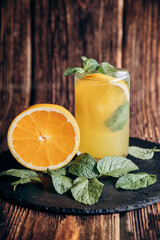 Fresh orange juice and slices is poured into glass. Vitamins food.Ripe. Healthy vegan food.