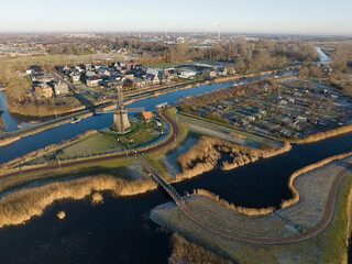 Strijkmolen E, Ouddorp, Alkmaar, North Holland,The Netherlands. Oak octagonal polder mill from 1630. Ironing mills do not drain polders, grind the water from one reservoir to the other. Winter aerial. © Sepia100