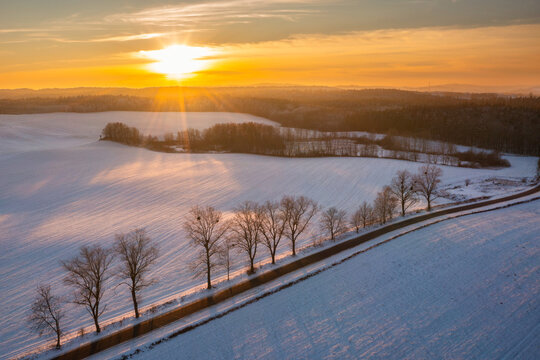 Snowy road in Kashubia at sunset, Poland