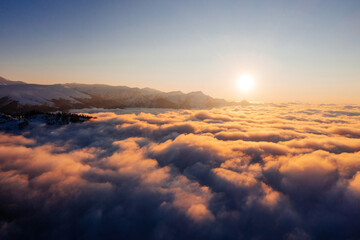 Fototapeta na wymiar Caucasian mountains above the clouds at the sunset. Cloudscape, aerial view