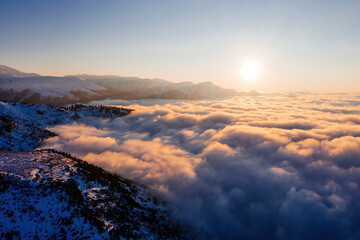 Caucasian mountains above the clouds at the sunset. Cloudscape, aerial view