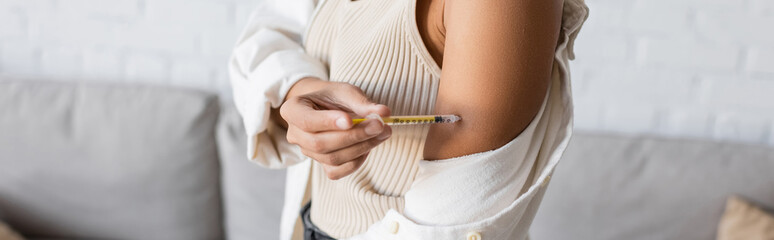 Cropped view of african american woman with diabetes doing insulin injection in arm, banner
