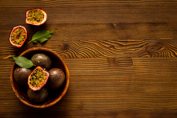 Ripe fresh passion fruit - marakuya - in wooden bowl. Top view