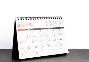 month february 2023 desk calendar for planners and reminders on a black table on a white background.
 - obrazy, fototapety, plakaty