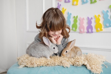 Girl with bunny rabbits in easter interior