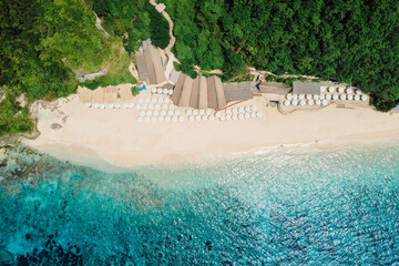 Aerial view of ocean and tropical beach with umbrellas in Bali