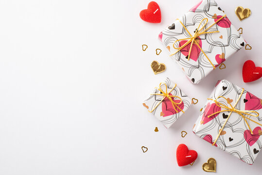 Valentine's Day concept. Top view photo of gift boxes candles and golden heart shaped confetti on isolated white background with copyspace