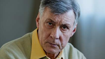 Close-up male portrait webcam view at home Caucasian angry mad face elderly serious old man looking...