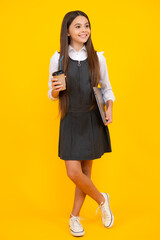 Child with coffee or tea cup isolated on yellow studio background. Teenage girl with take away beverage.