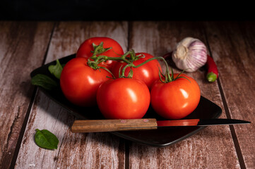 Red tomatoes lie on the table in the kitchen 
