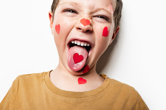Anonymous boy showing tongue with paper heart