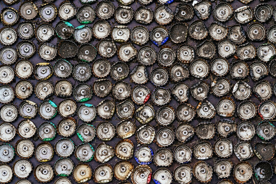 Abstract background of pile of metal bottle caps on wall