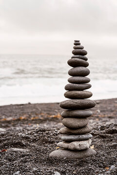 Stack of balancing rock on seashore on overcast day