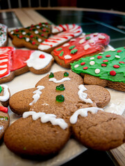 Collection of gingerbread Christmas cookies decorated with red, white and green frosting in the shape of trees, men, hats and other holiday symbols