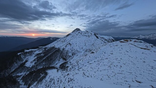 Winter picturesque mountain valley snow cliff peak altitude natural environment sun sky horizon sunset sunrise aerial view. Rocky frozen panorama cloudscape alpine wilderness travel dark landscape 4k